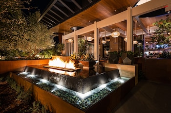 A modern restaurant with a unique chandelier, comfortable seating, and a green wall backdrop. at Durango Casino & Resort
