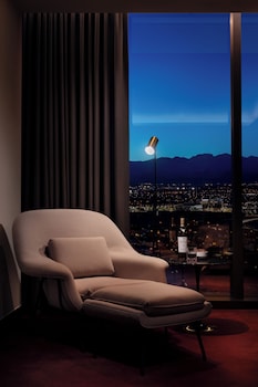 A modern hotel room with a large bed, a TV, a desk, and a view of the cityscape. at Durango Casino & Resort
