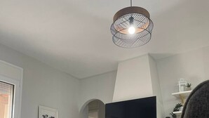 Un salon moderne avec une cheminée, un téléviseur à écran plat et un fauteuil gris.
