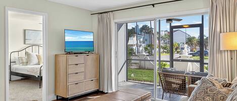 A spacious living room with a large sliding glass door leading to an outdoor patio.