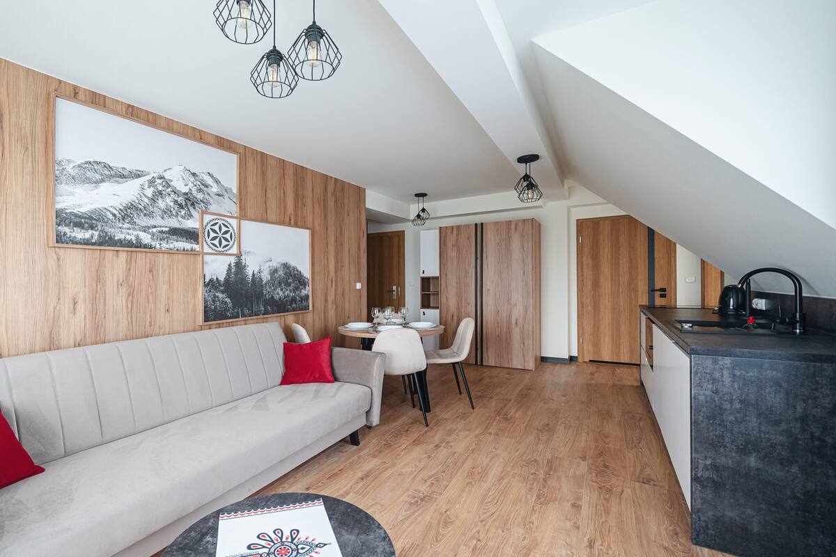 Un salon moderne comprenant un canapé, une table à manger et un coin cuisine.