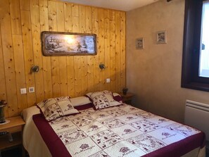 Cozy bedroom with a bed, bedside tables, and a framed picture above.