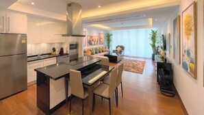 Una cocina moderna con una isla central, electrodomésticos integrados y una zona de comedor con sillas.