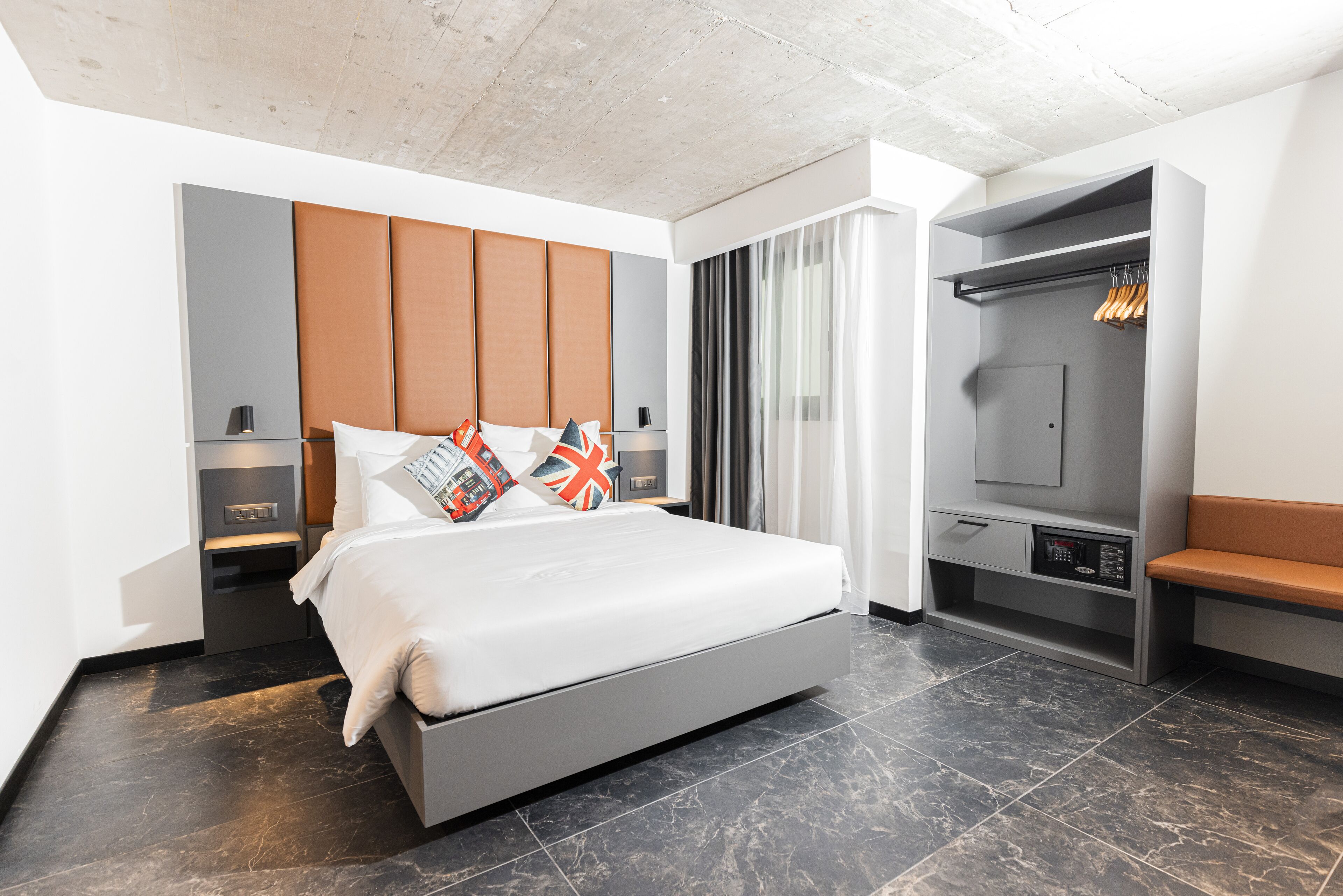 Un dormitorio moderno con una cama grande, un armario y una zona de estar.