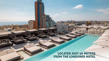 Una piscina al aire libre de temporada, sombrillas