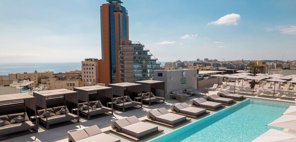 Una piscina al aire libre de temporada, sombrillas, tumbonas