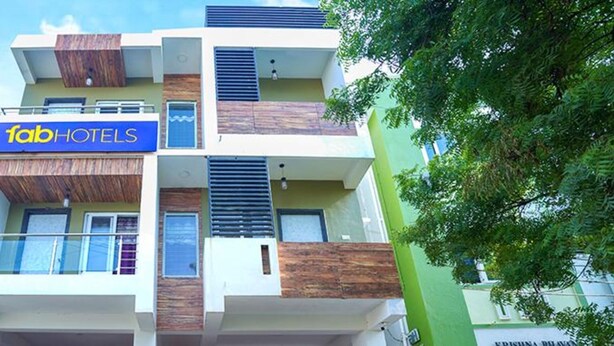 A multi-story building with a sign for 'fab hotels'. - Fabexpress Srinivasan Apartment (Vandavasi)