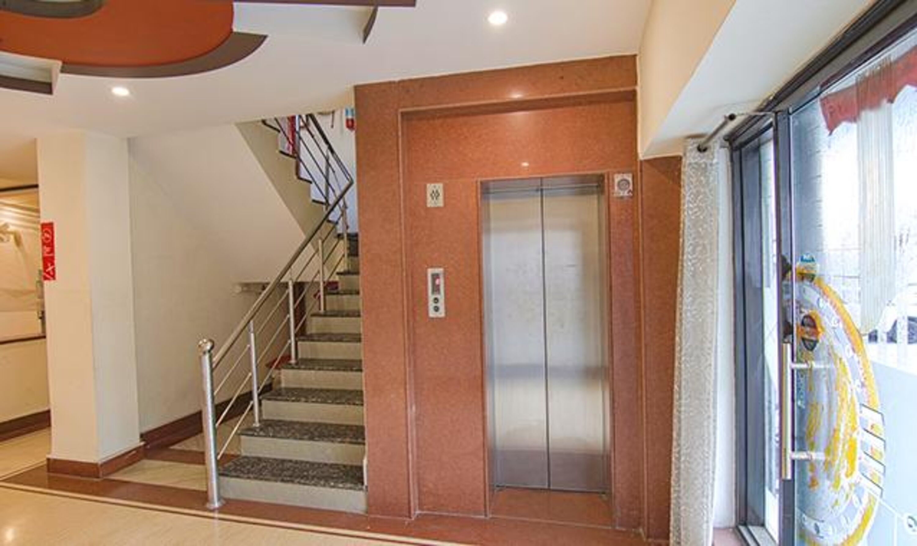 Un interior con una escalera que lleva a un ascensor.