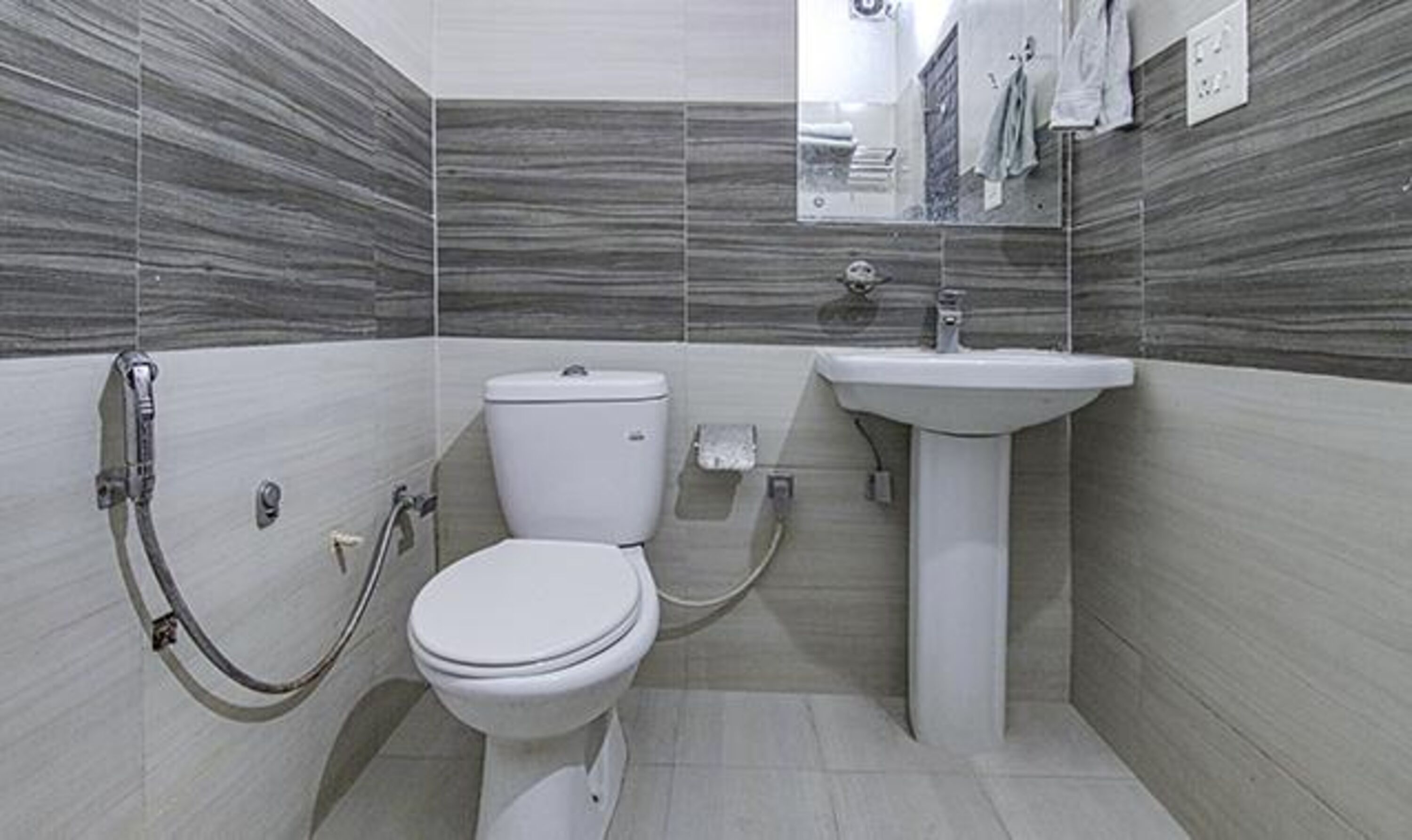 A bathroom with a toilet, bidet, and sink.