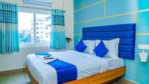 Ein Bett mit Holzrahmen, weißer Bettwäsche und blauen Akzenten.