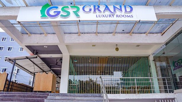 Ein Gebäude mit einem Schild für 'Grand Luxury Rooms' und einem verschlossenen Eingang.