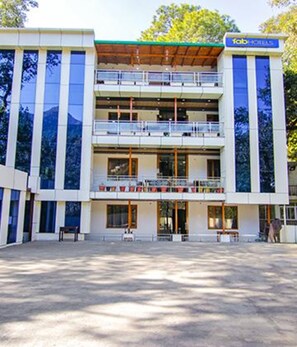 A modern hotel with a two-story structure, large windows, and a balcony on the upper floor. - Fabhotel Wildflower Inn (Nainital)