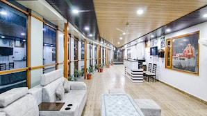 A modern hotel lobby with a long corridor, seating area, and a reception desk. - Fabhotel Wildflower Inn (Nainital)