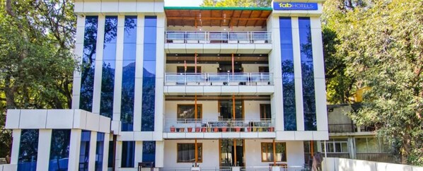 A modern building with a 'fab hotels' sign, multiple balconies, and large windows. - Fabhotel Wildflower Inn (Nainital)