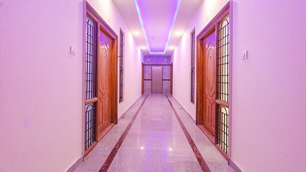 A hallway with wooden doors and barred windows, leading to a room with a closed door. - Fabhotel Elite Inn (Bengaluru)