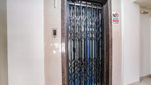 An elevator with a metal gate and a 'No Outside Food Allowed' sign. - Fabexpress Jasmin Rooms (Pune)