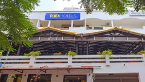 Ein Gebäude mit einem 'fabHOTELS'-Schild, einem überdachten Außenbereich mit Pflanzen und einem 'BANQUET'-Schild.