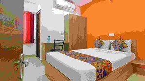 A bedroom with a bed, a desk, and a wardrobe. - Fabexpress Star Kinghood Inn (Hyderabad)