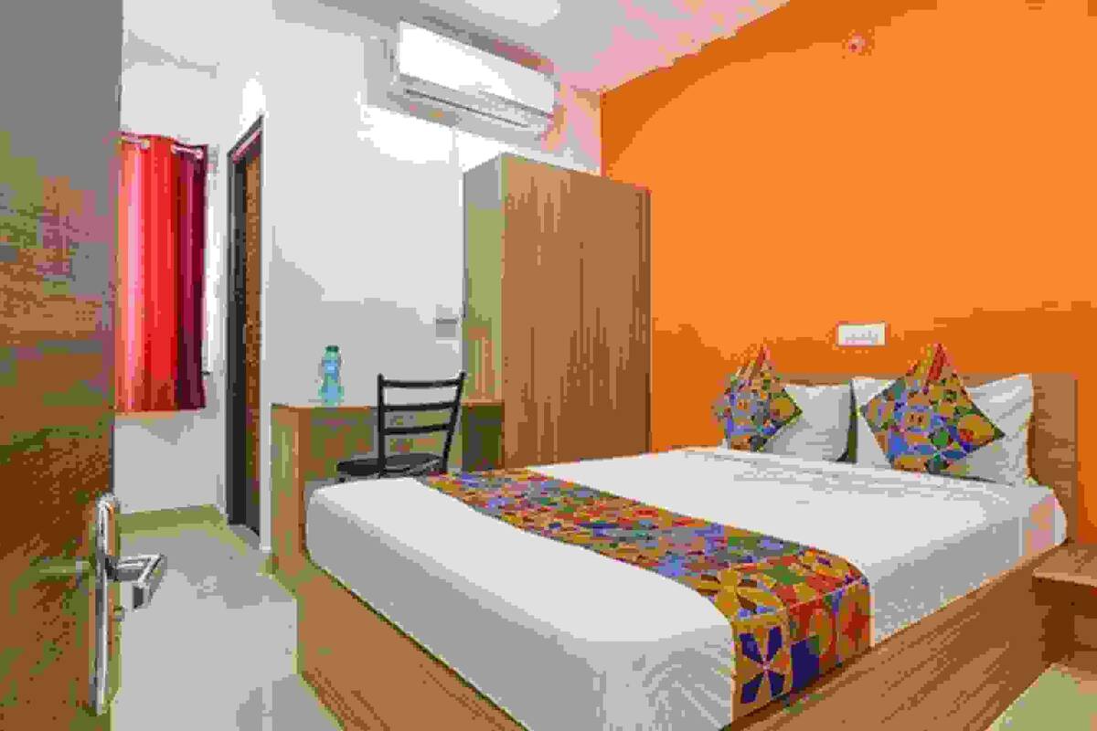 A bedroom with a bed, a desk, and a wardrobe.