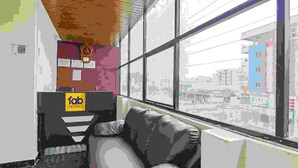 A hotel reception area with a check-in counter, a seating area, and a view of the cityscape through large windows. - Fabexpress Star Kinghood Inn (Hyderabad)