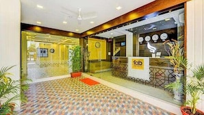 A hotel entrance with a patterned floor, a reception desk, and a clock on the wall. - Fabhotel Ruchikkoot Bay (Chennai)