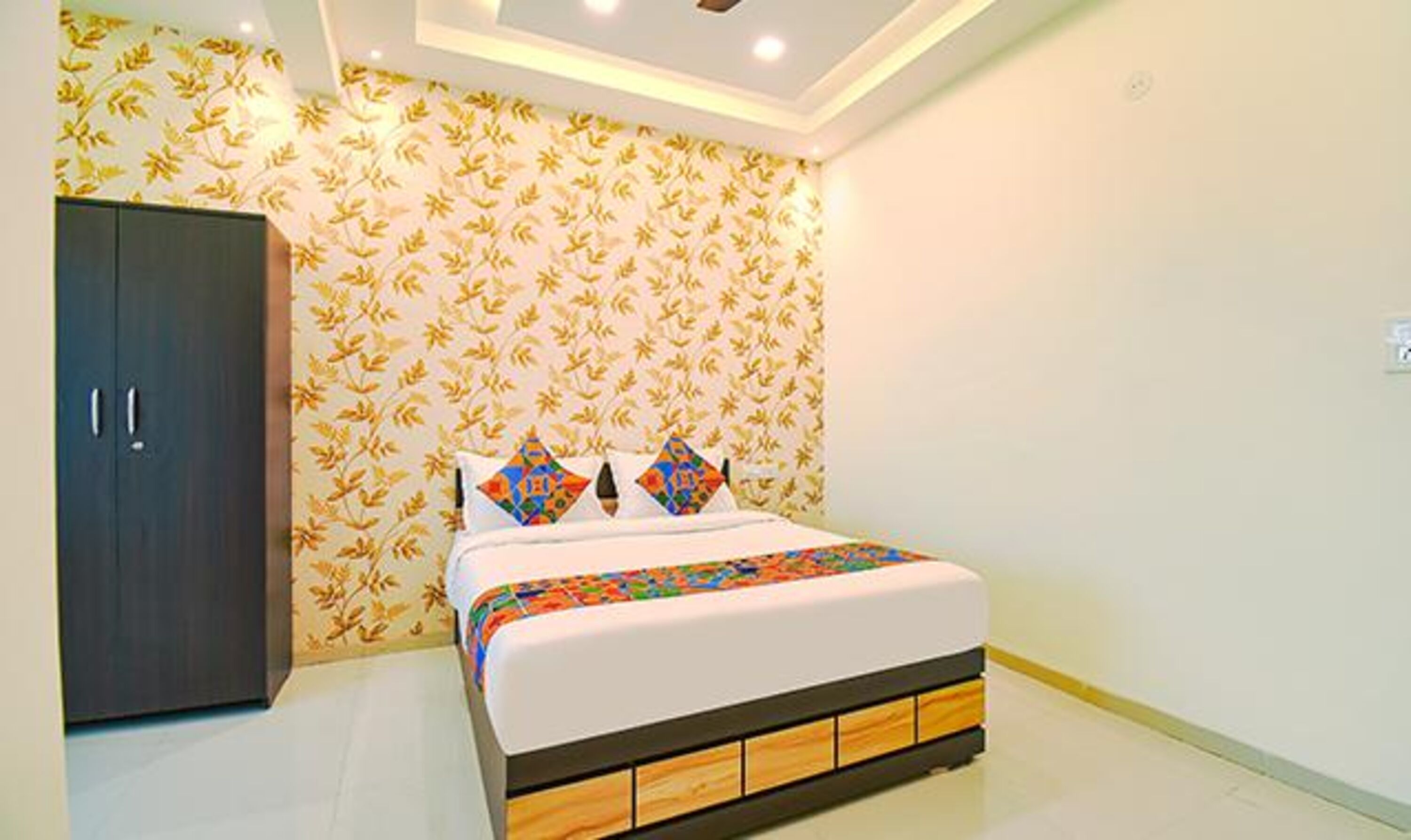 A bedroom with a bed, a wardrobe, and a patterned wallpaper.