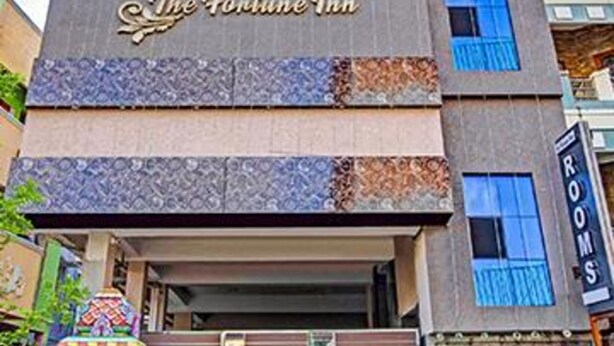 Un edificio de varios pisos con un letrero que indica 'Tab Hotels' y 'The Fortune Inn', señalando que es un hotel.