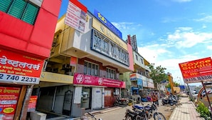 A row of commercial buildings with signs for hotels and businesses. - Fabhotel Rs Apartment (Pune)