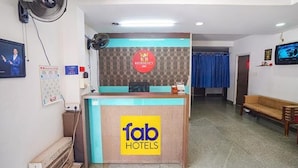 A hotel reception area with a reception desk, a clock, and a seating area. - Fabexpress Svs Residency (Chennai)