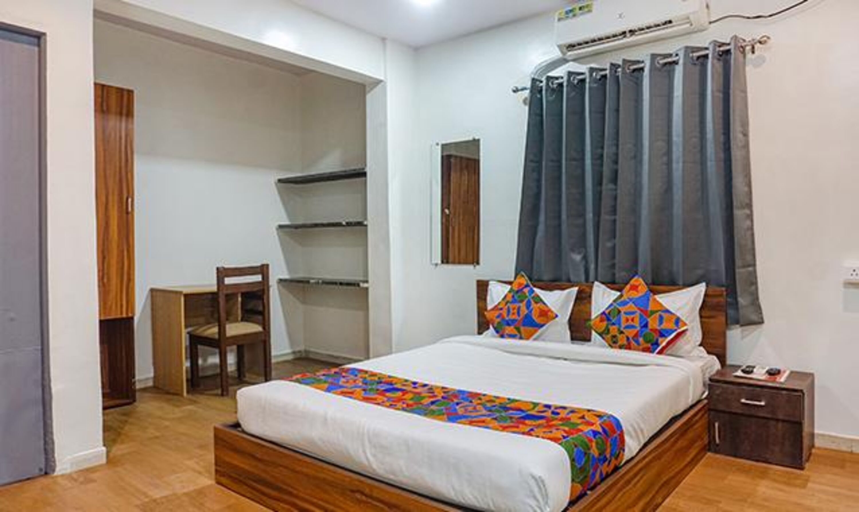 A bedroom with a bed, a desk, and a chair.