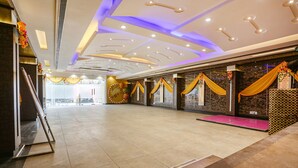 A spacious hall with a high ceiling, recessed lighting, and decorative drapes. - Fabhotel Mng (Kanpur)