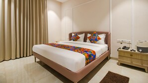 Ein Hotelzimmer mit Bett, Nachttisch, Telefon und einer Kaffeemaschine.