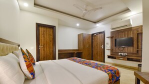 A hotel room with a bed, wardrobe, TV, and ceiling fan. - Fabhotel The Palm (Jaipur)