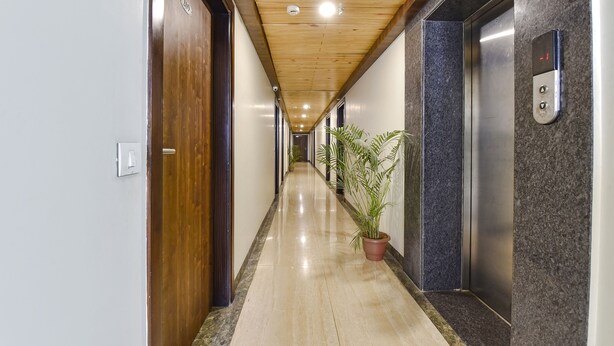 A hallway with wooden ceiling, a potted plant, and an elevator. - Fabhotel The Palm (Jaipur)