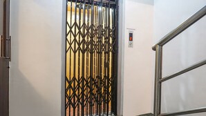 A door with a metal security gate, a digital display, and a metal handrail. - Fabhotel Royal Samrat (Pune)