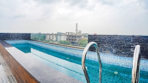 A rooftop swimming pool with a clear view of buildings and a communication tower in the background. - Fabhotel Prime Ocean Breeze (Bhopal)