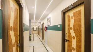 Un couloir avec des portes, un extincteur et un panneau indiquant le numéro.