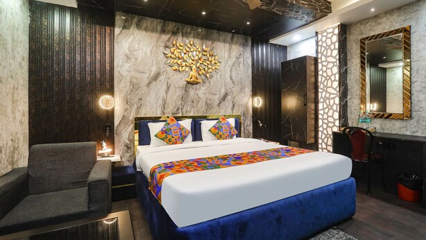 Une chambre d’hôtel moderne dotée d’un grand lit, d’un coin salon et d’un bureau.