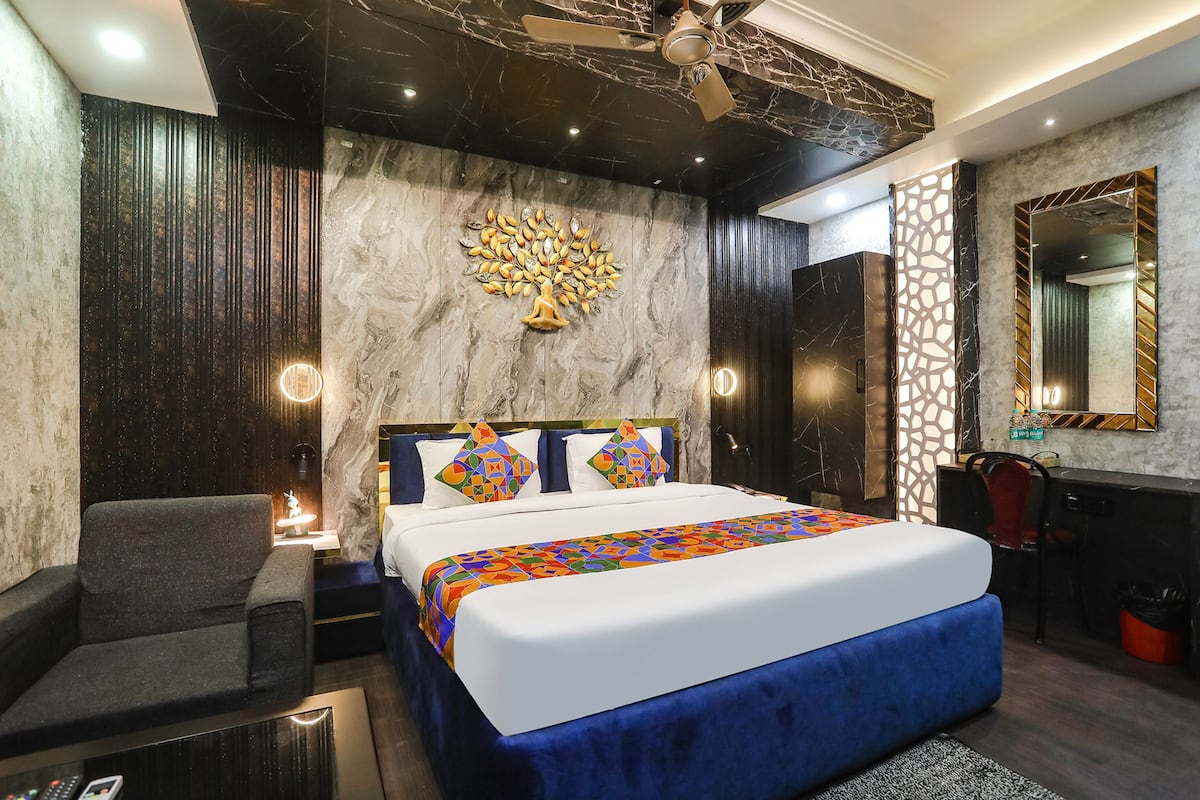 Une chambre d’hôtel moderne dotée d’un grand lit, d’un coin salon et d’un bureau.