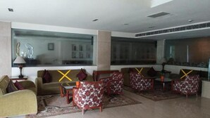 Un hall d’entrée moderne avec une grande fenêtre, un ensemble de canapés et une table basse.