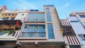 Un hotel llamado Haidri-Inn con un letrero visible, un balcón con barandillas y una antena parabólica.