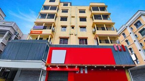 Un edificio de varios pisos con fachada roja y un cartel que dice 'Tabernas'.