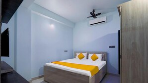 Une chambre à coucher moderne, équipée d’un lit, d’un ventilateur de plafond et d’un appareil de climatisation.