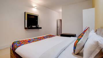 Un dormitorio con cama, mesita de noche, armario y espejo.
