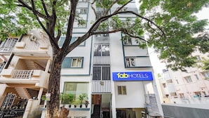 A multi-story building with a sign for 'fab HOTELS' on the facade. - FabHotel Happy Home Stay (Bengaluru)