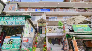 A multi-story building with various shops on the ground floor, including a restaurant and a hotel. - Fabhotel Nirvana Deluxe (Manali)