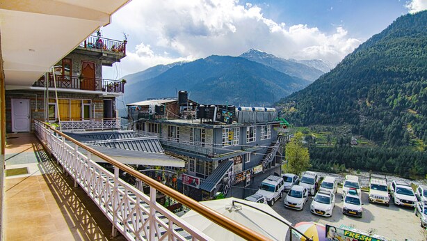 A hotel with multiple floors, balconies, and a view of a mountainous landscape. - Fabhotel Nirvana Deluxe (Manali)