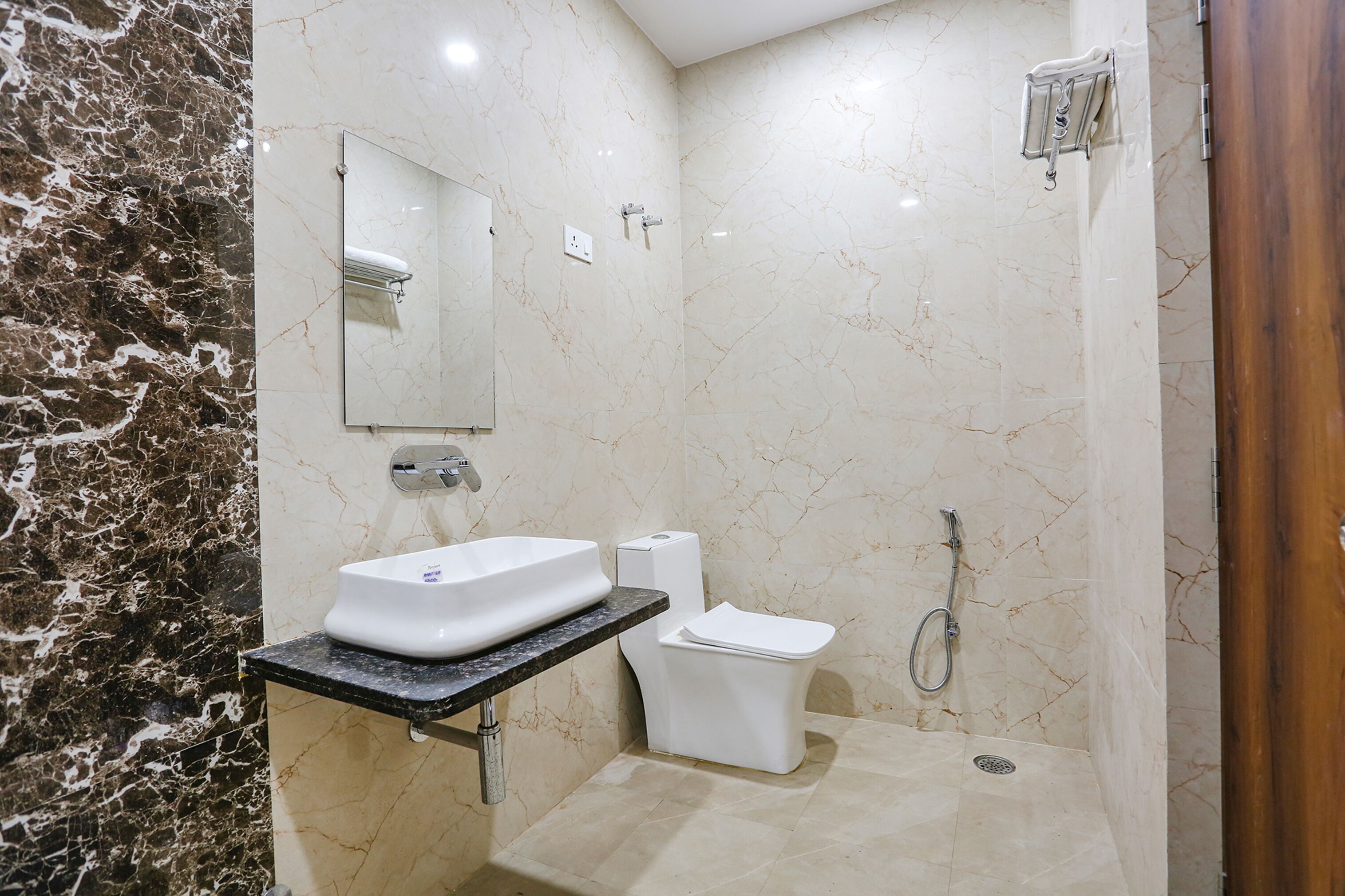 A bathroom with a marble sink, toilet, and shower.