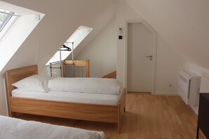 A bedroom with a wooden bed, a skylight, a radiator, and a door. - Ferienwohnung Brack in Gaggenau, Schwarzwald (Gaggenau)
