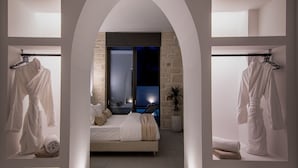A modern bedroom with a large bed, a balcony, and a view of the night sky. - Perla Dream Luxury Villa (Chania)